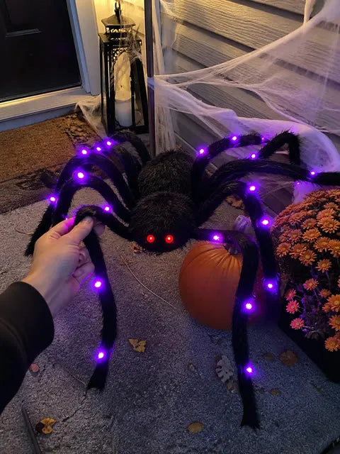 Furry light-up spider being arranged on a Halloween porch