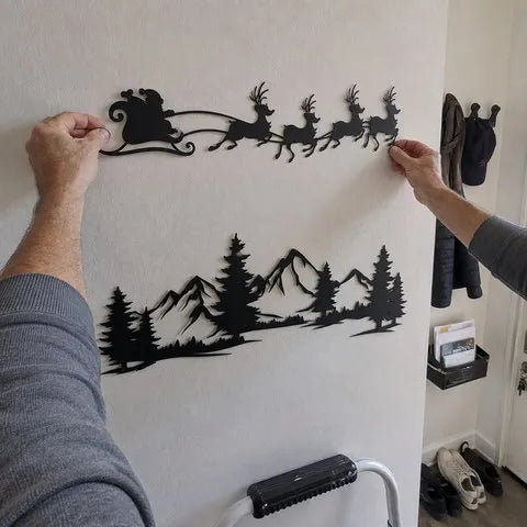 Homeowner aligning the Santa sleigh panel above the mountain scene