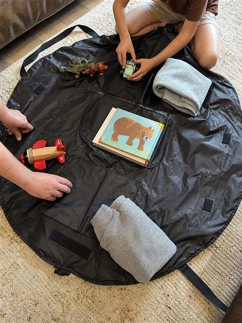 Black round organizer mat used for family trip packing