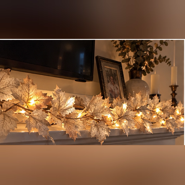 Glowing ivory maple leaf garland displayed across a home mantel