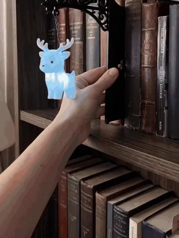 Stag, owl, and phoenix bookshelf lights glowing beside books