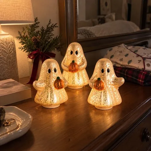 Three glowing ghost figurines on a guest-room dresser