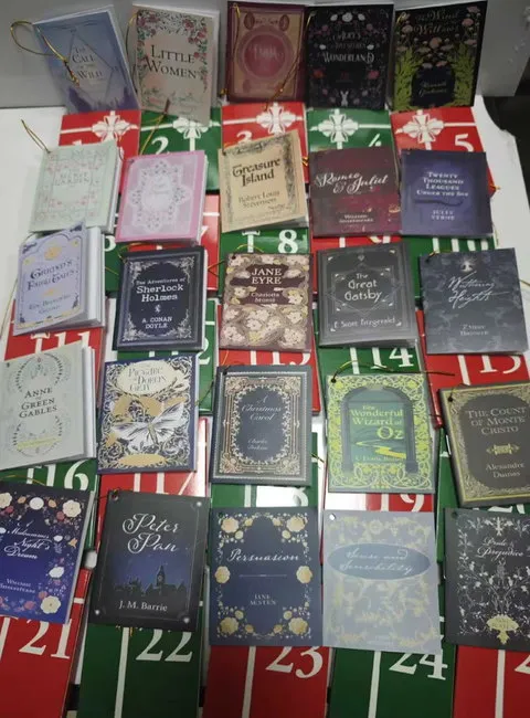 Complete collection of miniature book ornaments arranged across the numbered advent sleeves