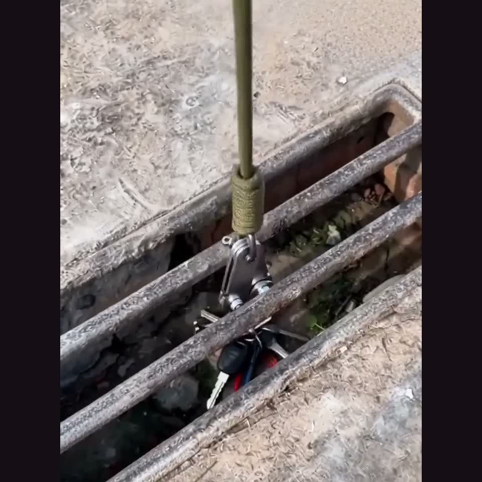 Opened hook retrieving a small item from a narrow ground-level gap