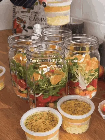 Layered salad jars being prepared with separate toppings and dressing