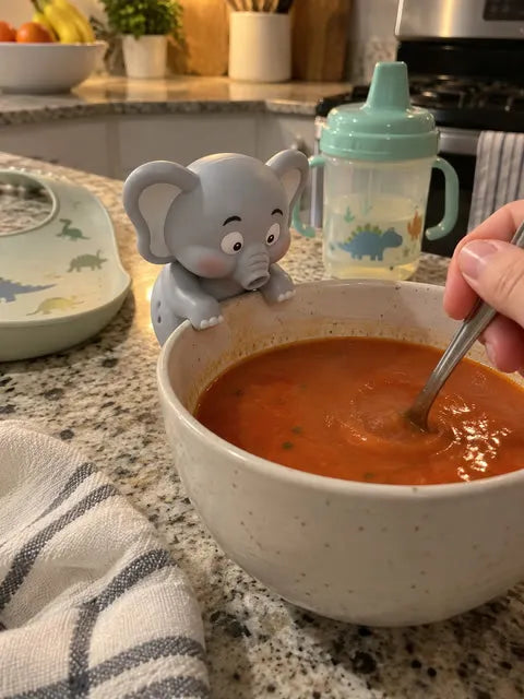Elephant fan beside a bowl of tomato soup