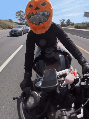 Pumpkin motorcycle helmet cover being fitted and shown during a group ride