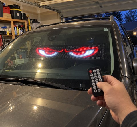 LED eye display installed inside an SUV windshield in a home garage