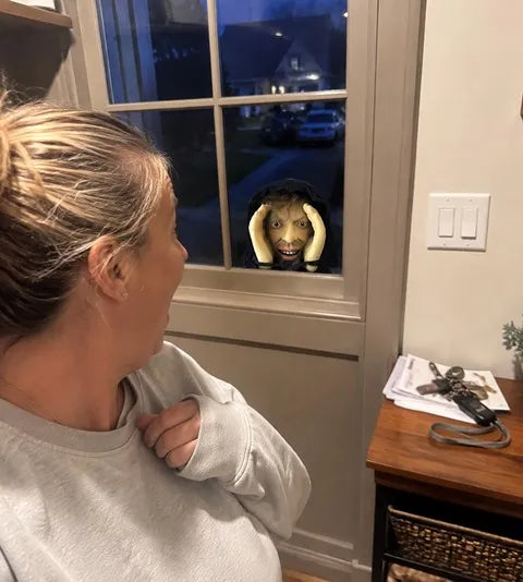 Window peeper prank prop outside a family entryway window