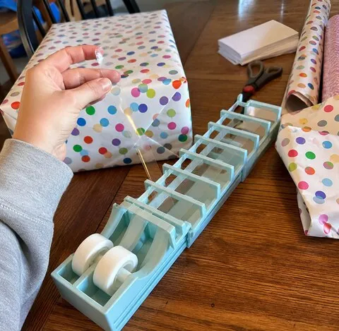 Tape strips prepared beside a birthday gift on a dining table