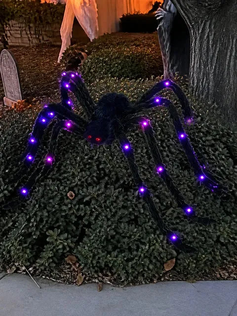 Purple light-up spider resting in a front-yard Halloween display