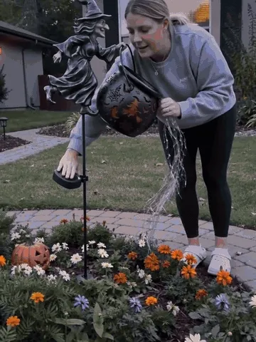 Witch cauldron garden light turning on and creating a colorful waterfall glow