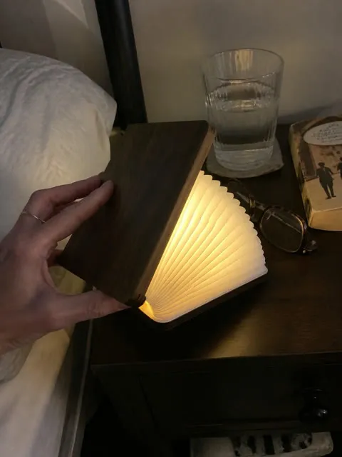 Folding book light on a lived-in bedroom nightstand