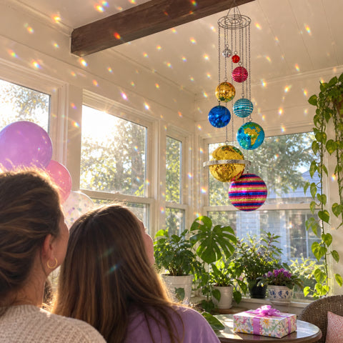 Hanging disco planet decor in a bright sunroom gift moment