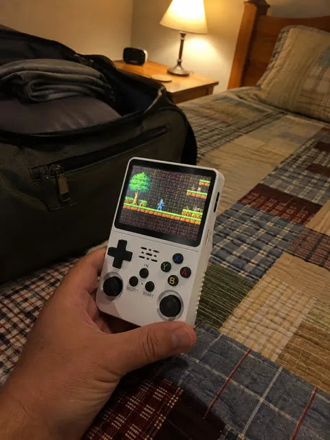 Handheld console beside a weekend travel bag