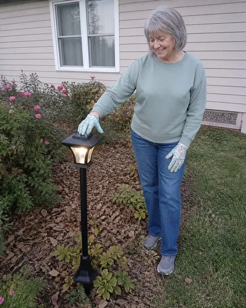 Gardener checking the solar panel on the courtyard lamp