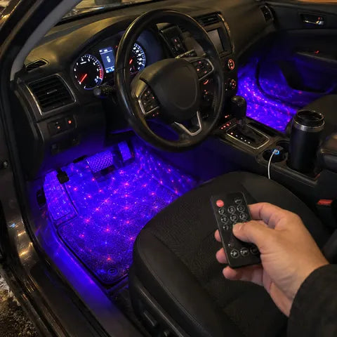 Driver using the remote to control purple footwell lighting