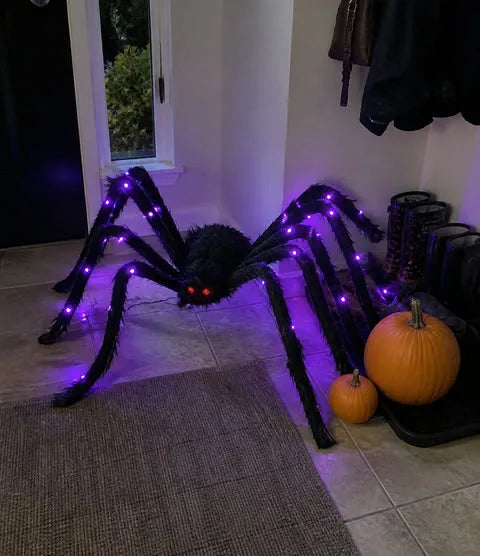 Purple light-up furry spider posed in a home entryway
