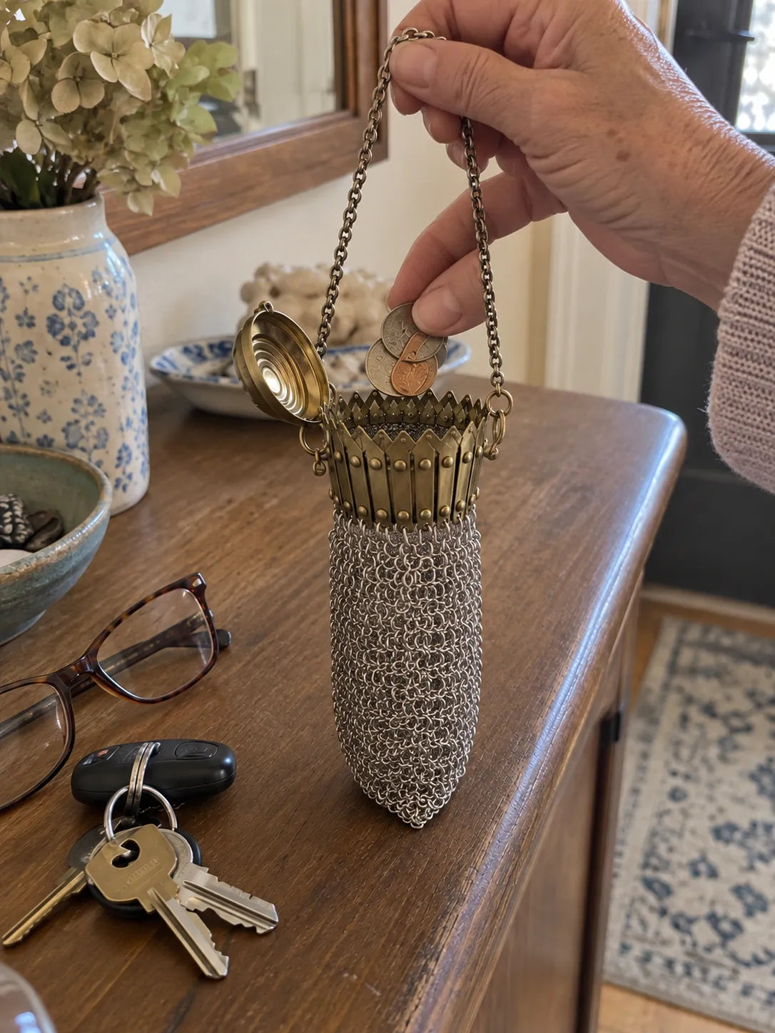 Vintage mesh purse holding loose change on an entryway table
