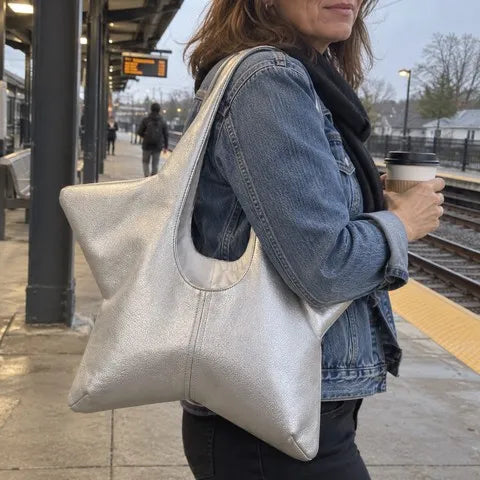 Silver star-shaped tote worn over the shoulder on a commuter train platform