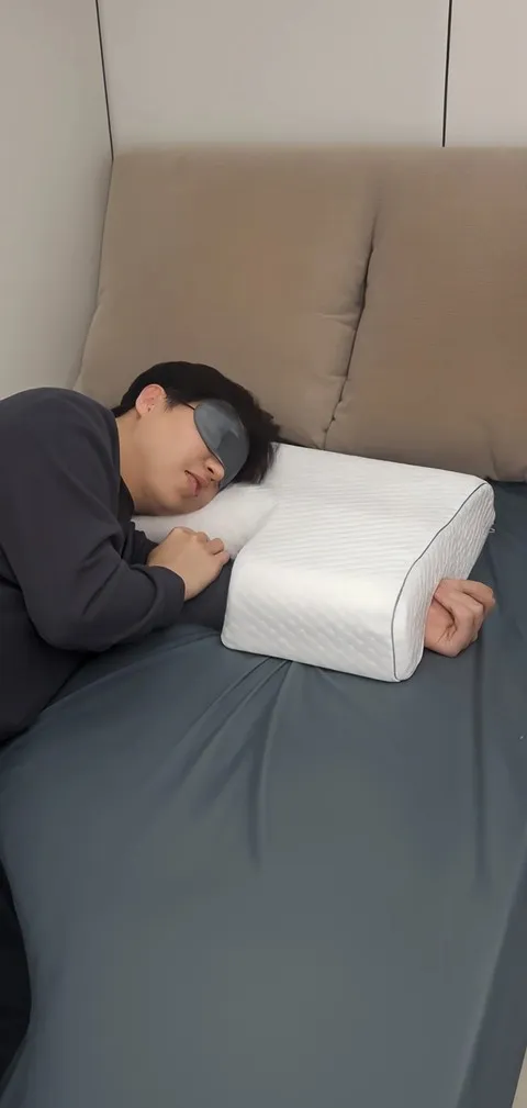 Side sleeper using the left-arm channel pillow in a bedroom