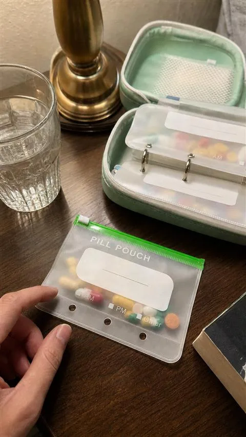 One removable pouch beside an open organizer on a nightstand