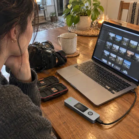 Photographer using the fingerprint SSD enclosure at a table