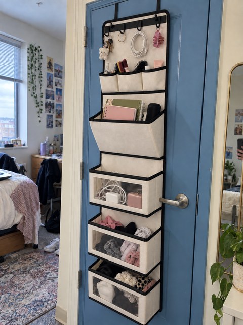 Bedroom door organizer holding notebooks, cords and accessories