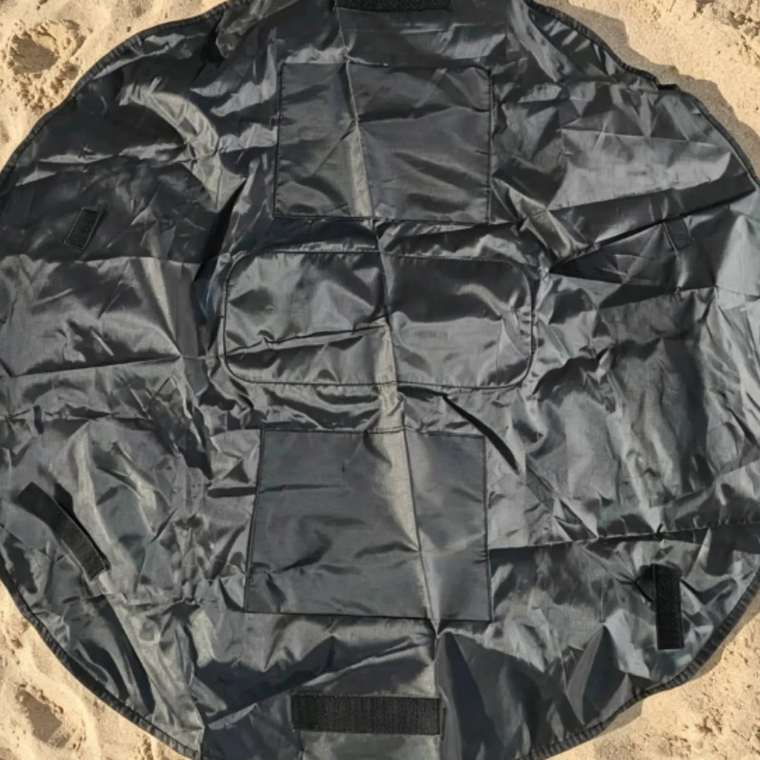 Black round organizer mat with multiple sewn storage sections