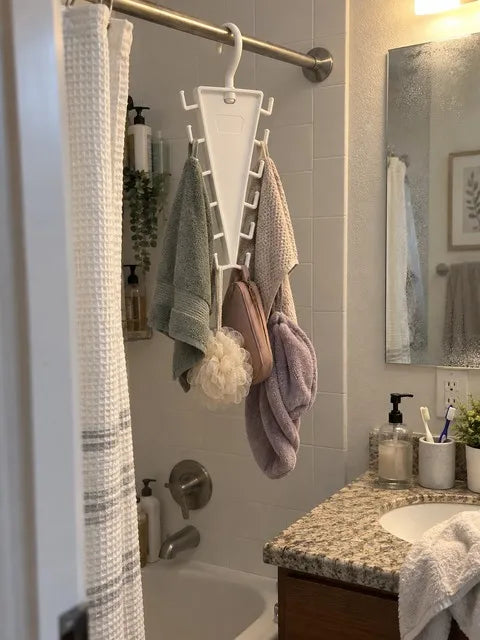 White hanging organizer holding towels and bath accessories from a bathroom rod