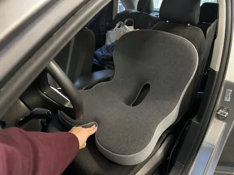 Integrated support cushion set upright on a family sedan driver seat