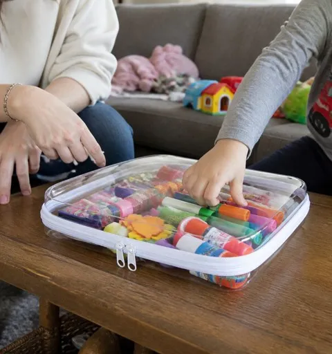 Large clear organizer holding colorful craft supplies on a family coffee table