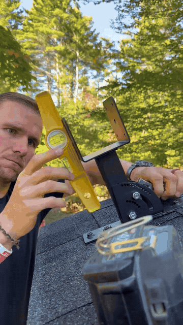 Installer leveling and locking an adjustable roof riser bracket on a shingle roof