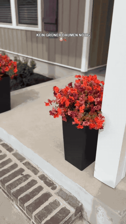 Zwei fertige kompakte Herbst-Kunstblumenarrangements auf einer Veranda