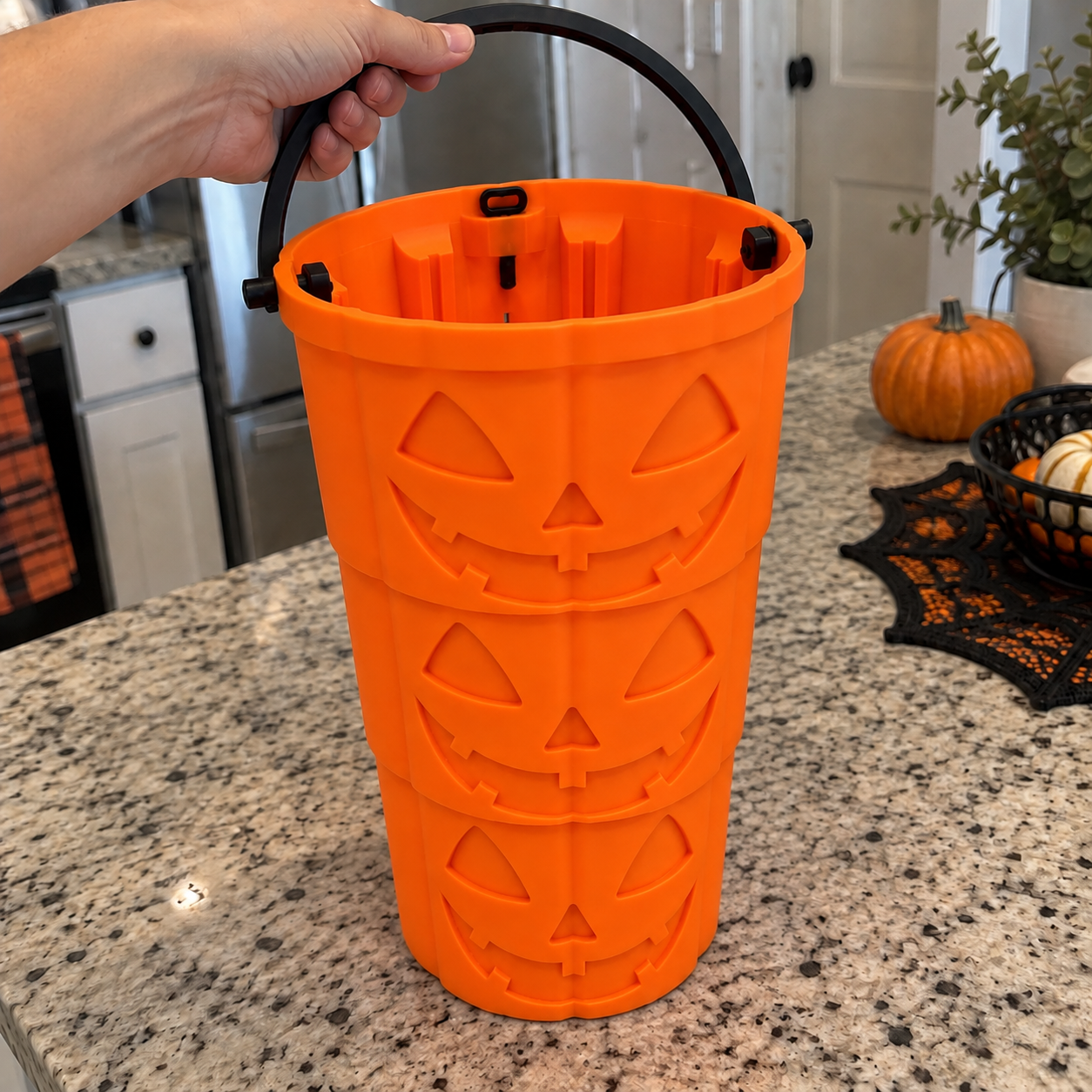Hand demonstrating the telescoping pumpkin bucket on a kitchen counter
