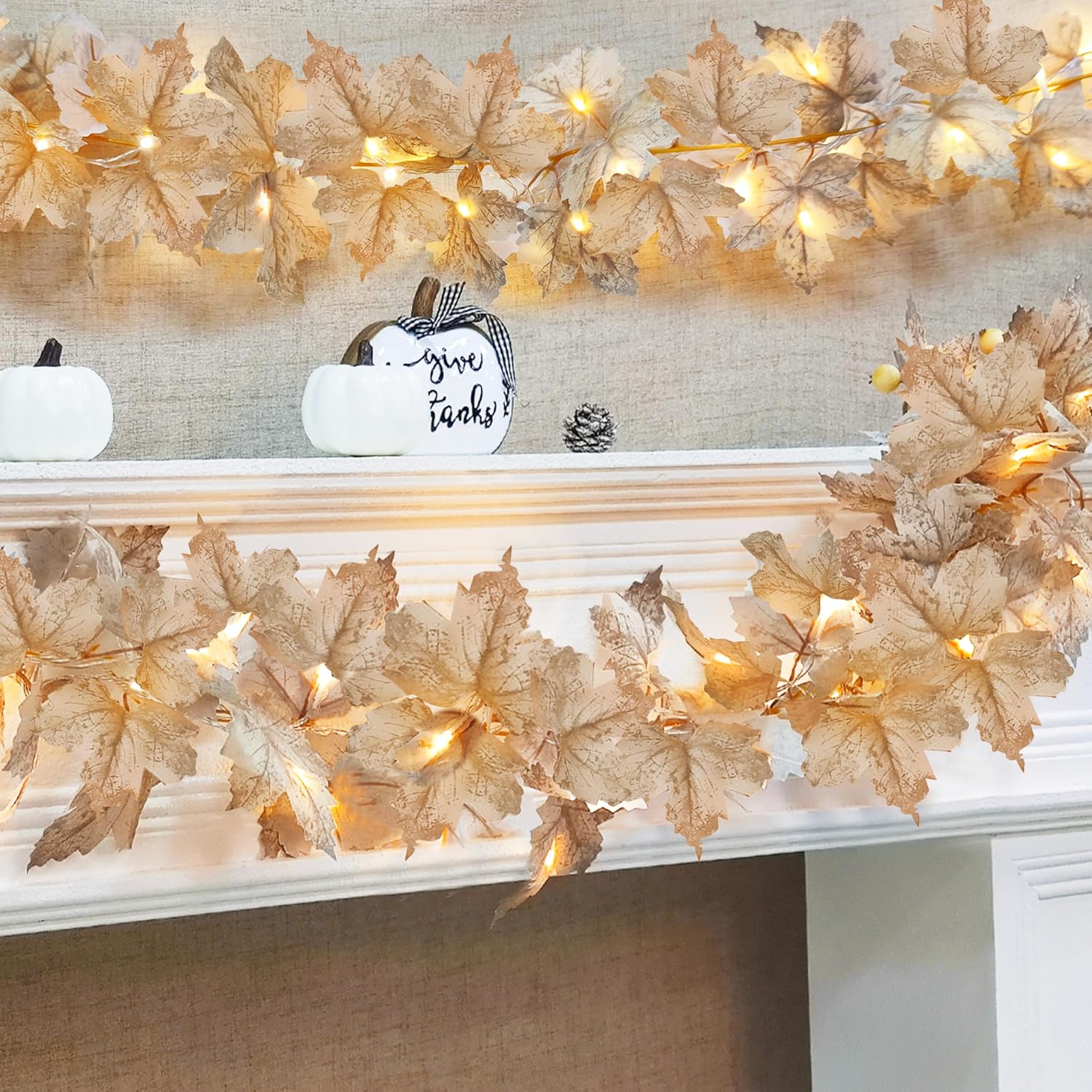 Ivory maple leaf light garland glowing across a fall mantel