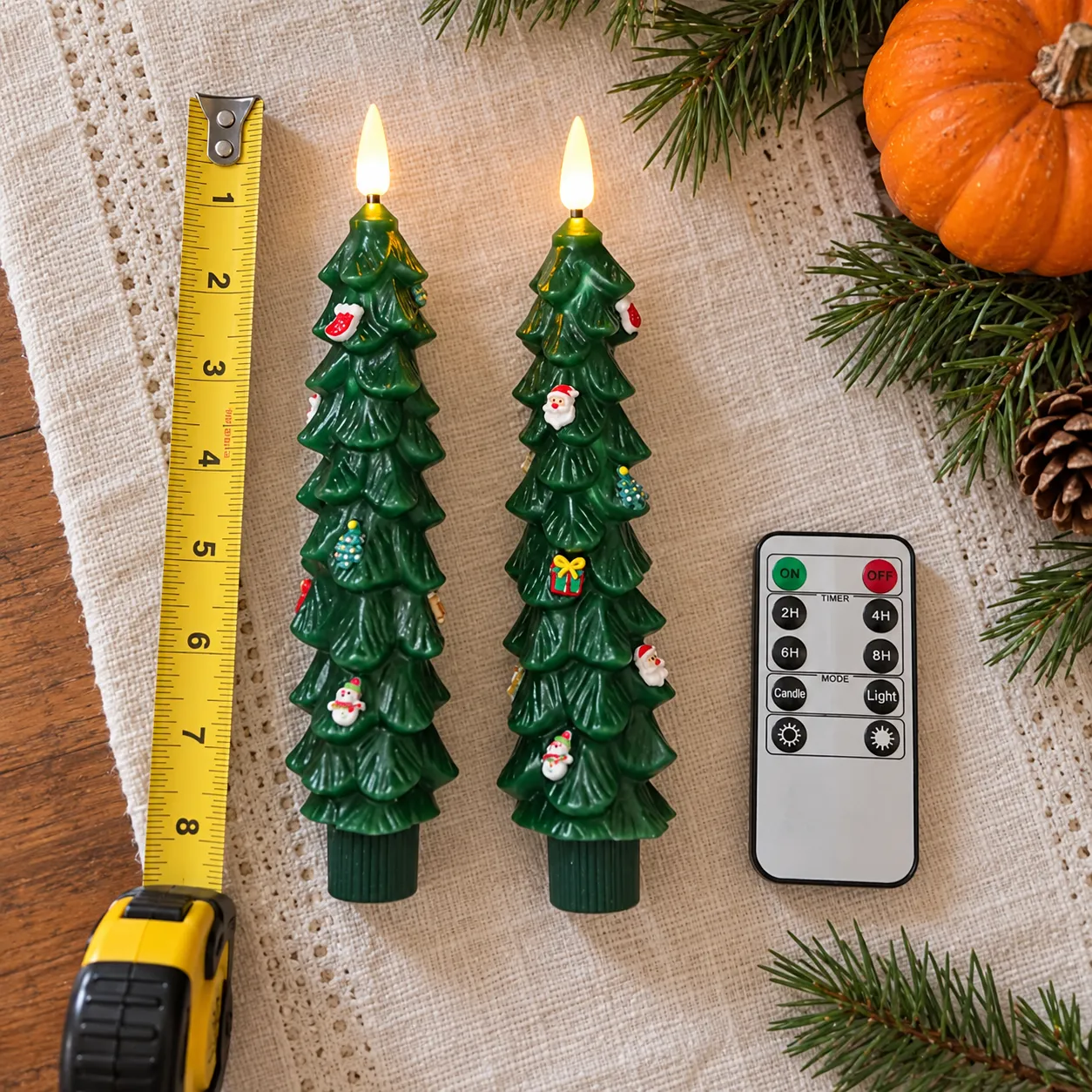 Two candles, remote, and household tape measure for size reference