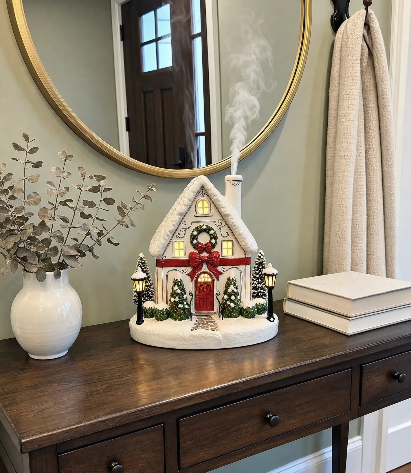Christmas village aroma diffuser glowing and misting on an entryway console