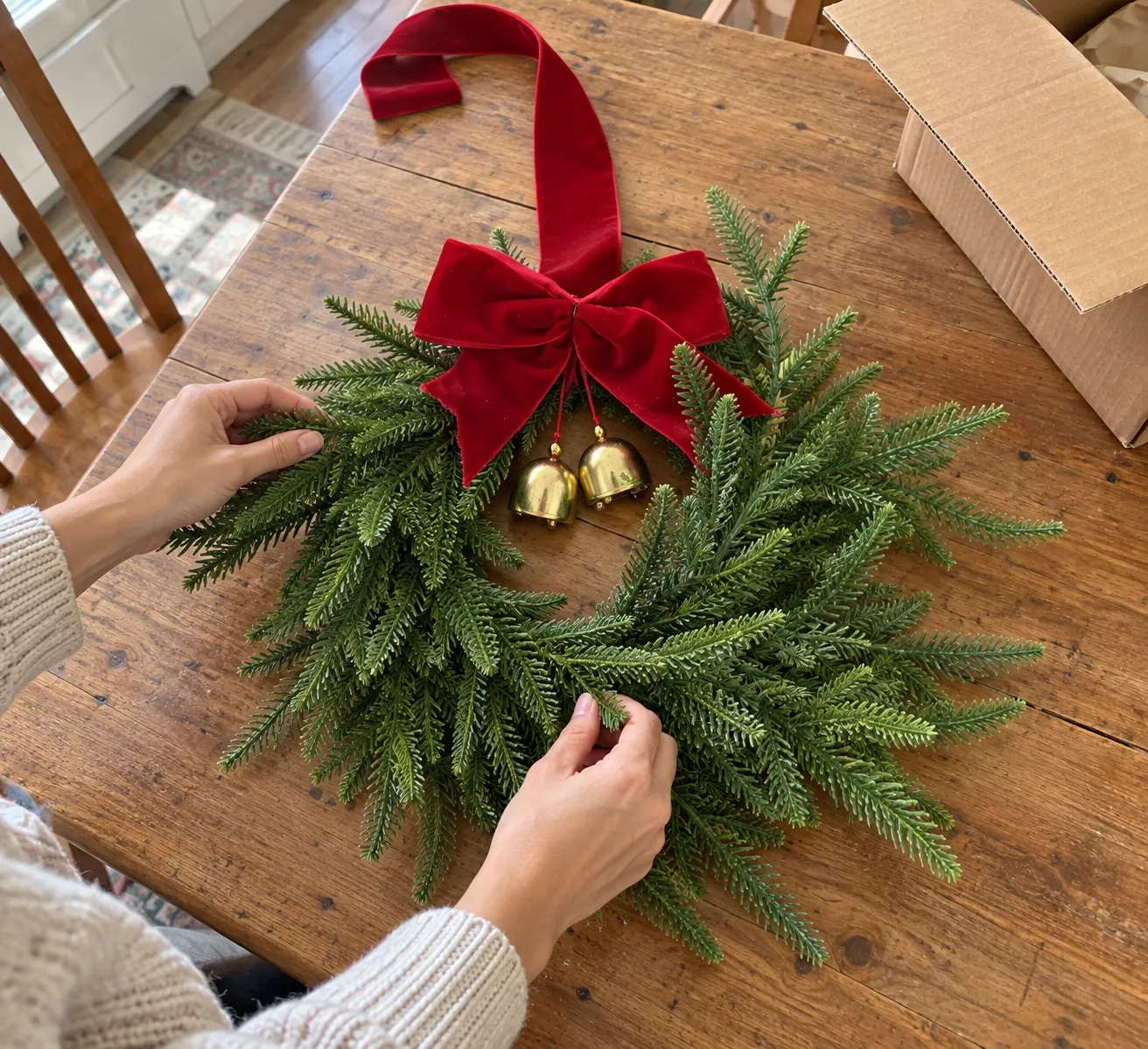 Hands fluffing Norfolk pine branches