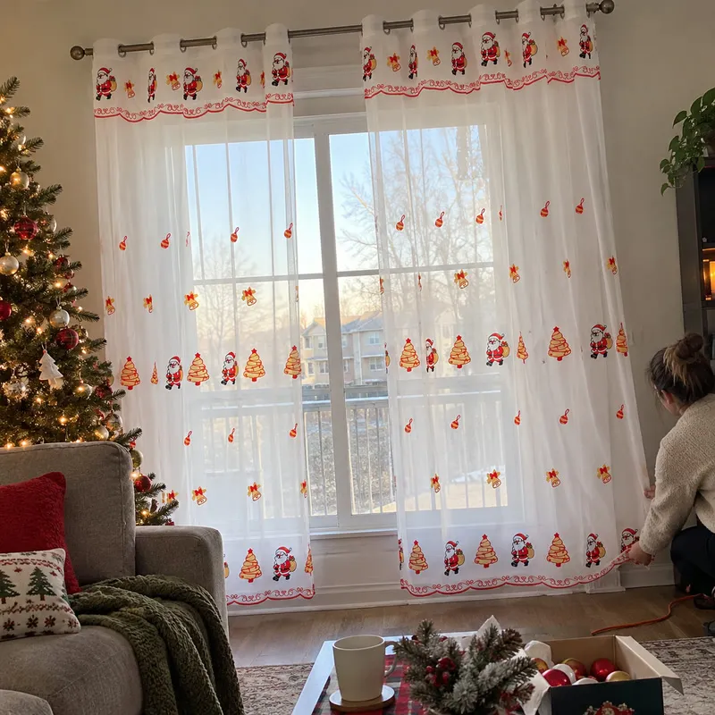 Christmas sheer curtain being arranged on a window rod