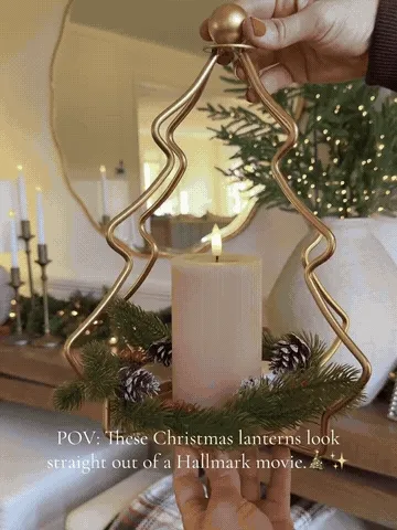 Gold tree candle holders being styled on a holiday mantel