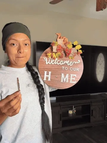 Hands changing the seasonal topper and center icon on the wooden welcome sign