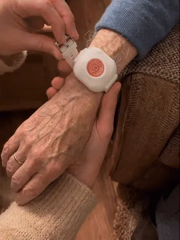 Older adult presses the wearable SOS button and a family member receives an alert