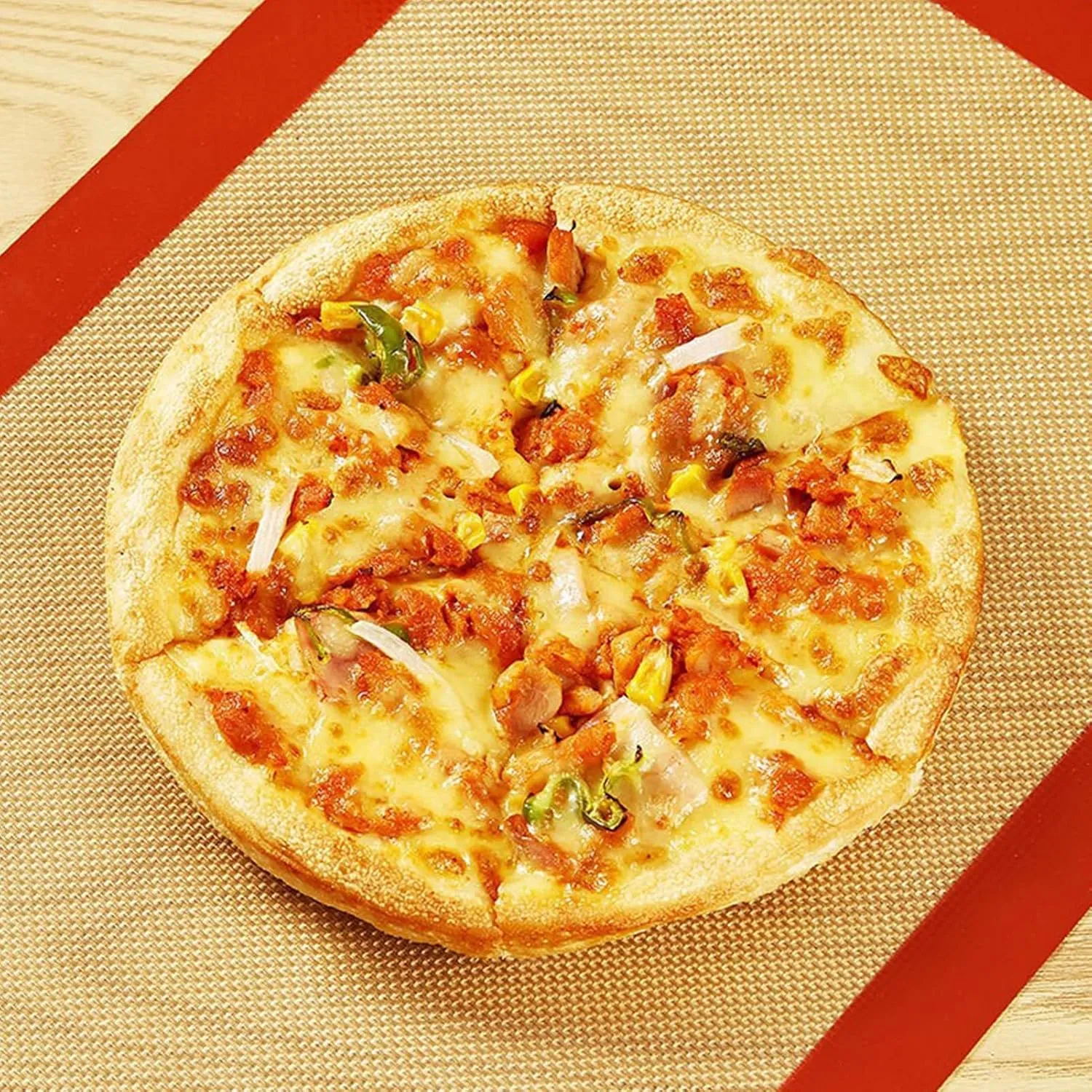 Pizza baking on a red reusable mat