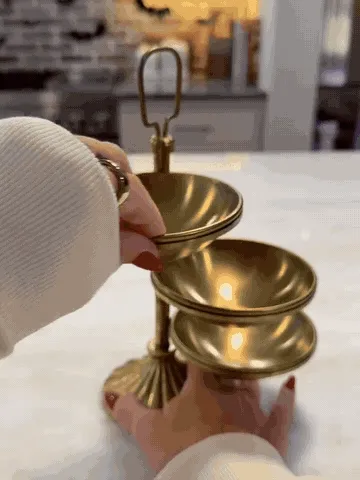 Three brass serving bowls swinging open and being filled with snacks