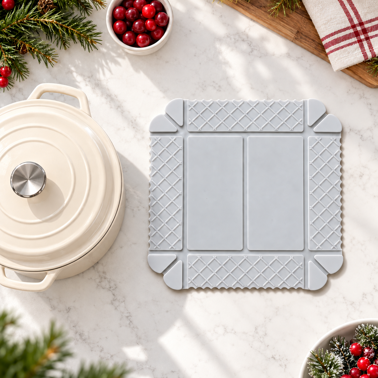 White foldable silicone mat beside cream cookware in a holiday kitchen