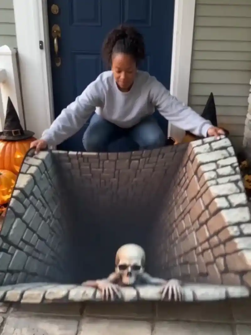 Skeleton pit illusion mat being placed at a Halloween entryway