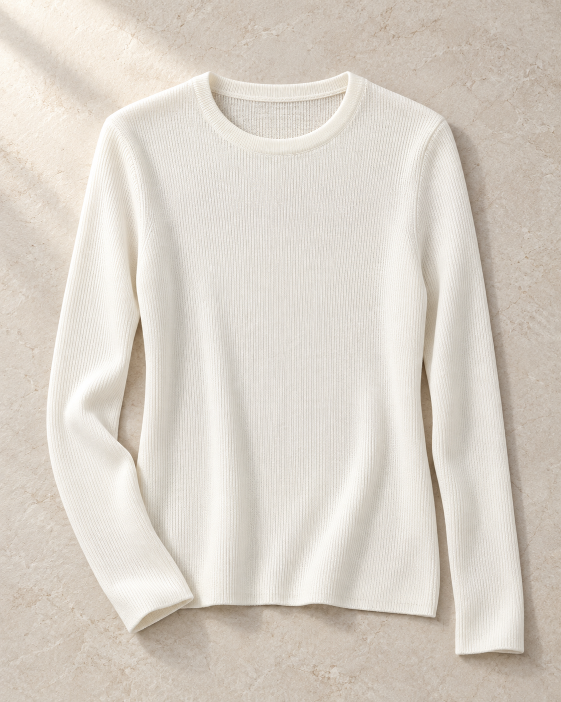 The Crewneck Knit in ivory, front editorial view showing its round neckline and fine vertical texture.