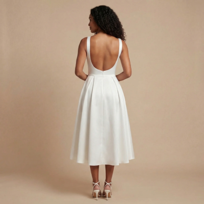 Back view of cream midi dress showing low open back and full pleated skirt