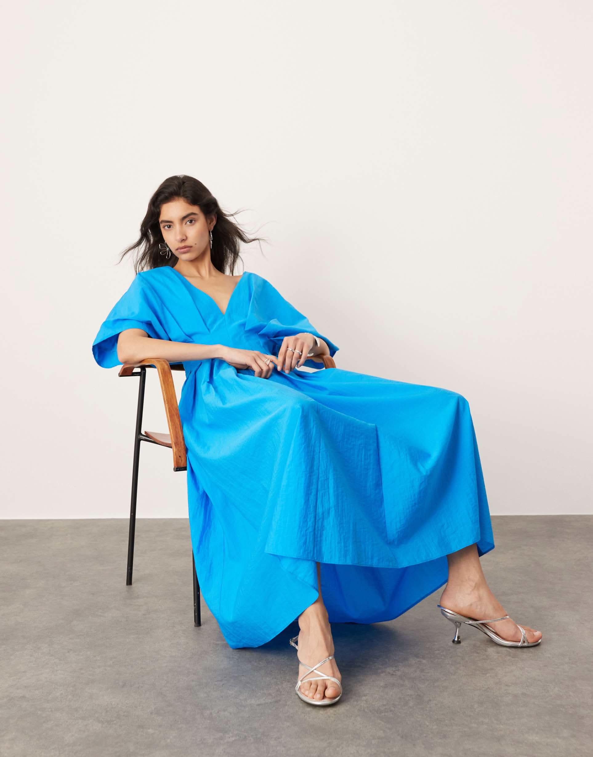 Blue midi dress seated view showing A-line skirt flow and wrap waist detail